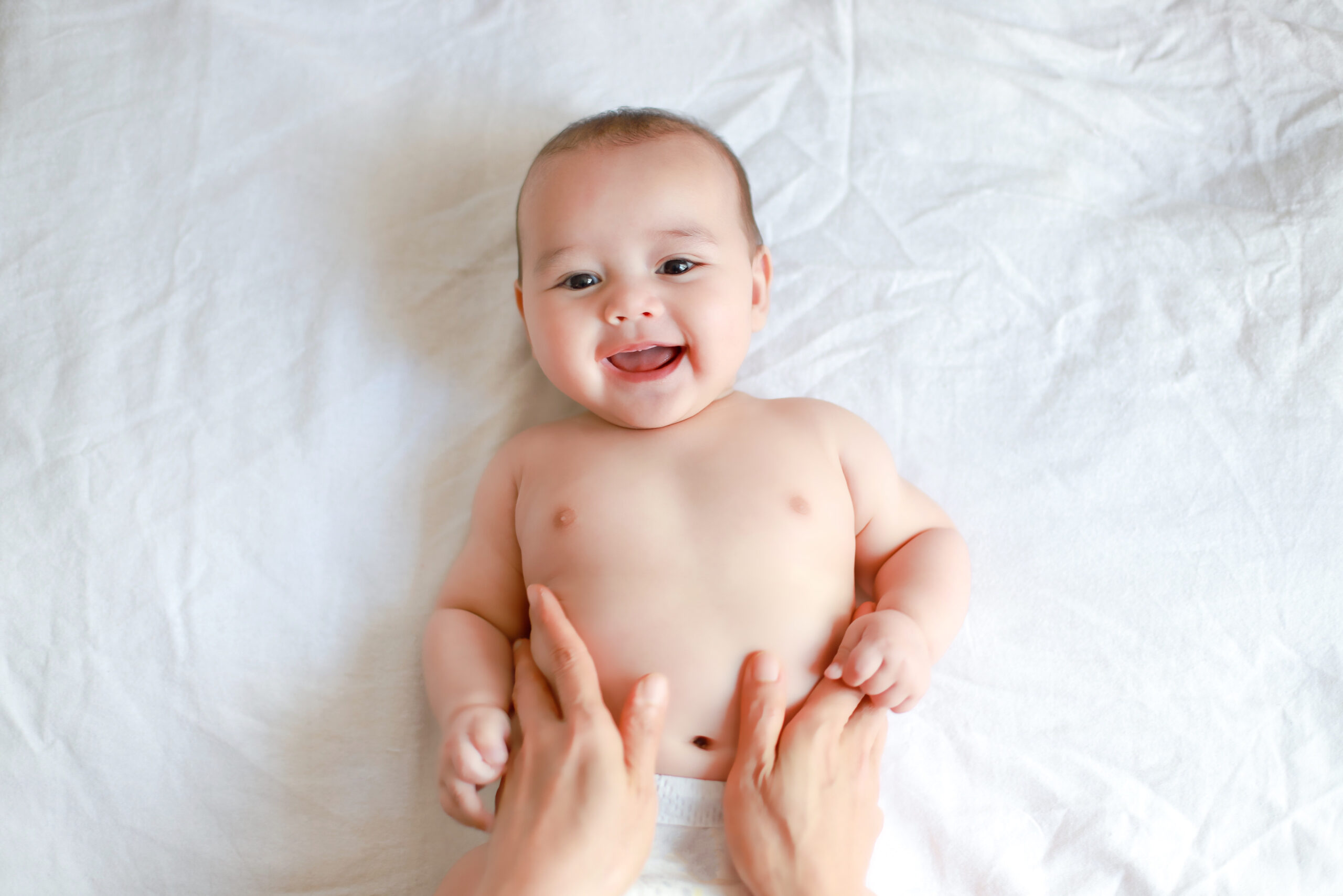 Adorable,Newborn,Baby,Boy,With,Smiling,Face,Top,View,Relaxing Parent massaging baby’s legs – exploring infant massage benefits