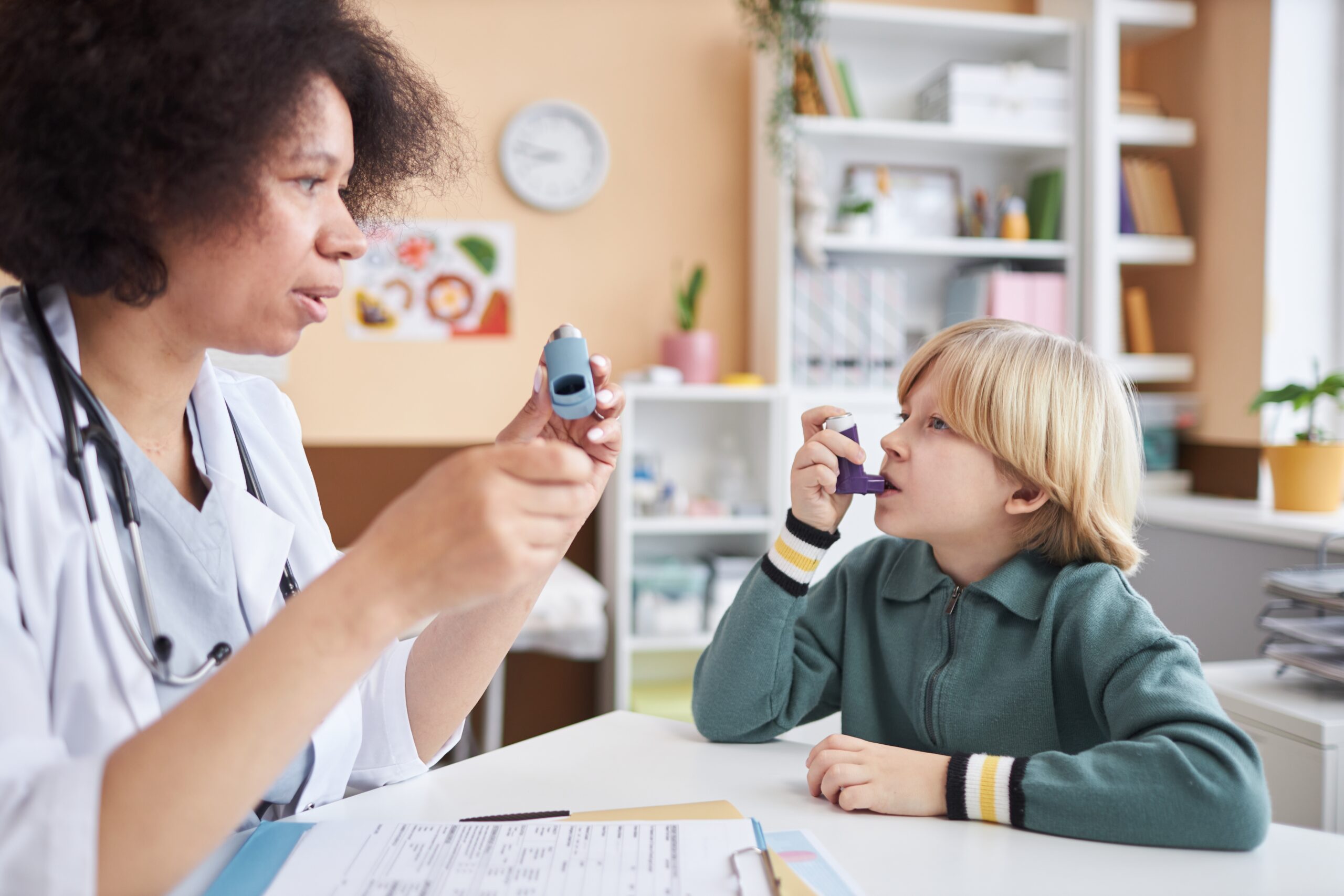 Side,View,Portrait,Of,Female,Pediatrician,Teaching,Little,Boy,Using Pediatrician instructing child on how to use an inhaler