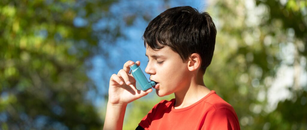 child playing sports and using inhaler