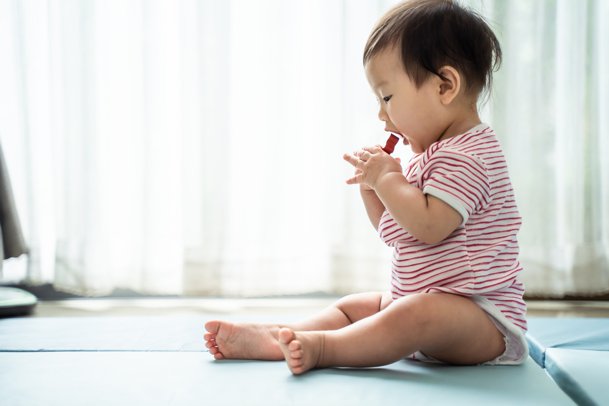 Asian,Cute,Baby,Holding,Toy,And,Trying,To,Eat,It,