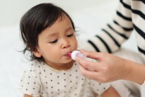 Parent giving vitamin D drops – vitamin D supplementation for newborns