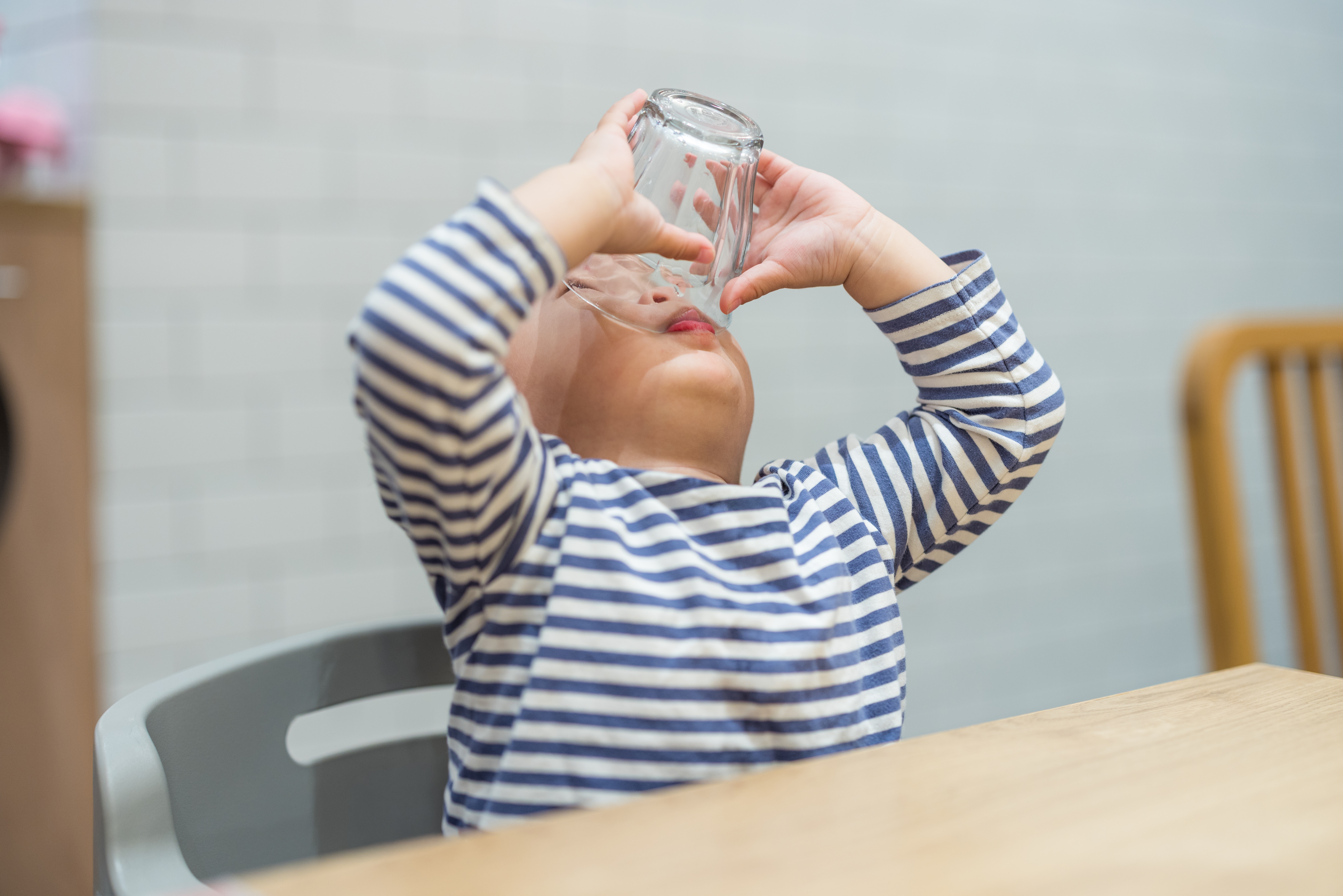 Toddler,Boy,Drinking,Last,Drop,Of,Water,From,Transparent,Glass water intake for kids baby drinking water during meals